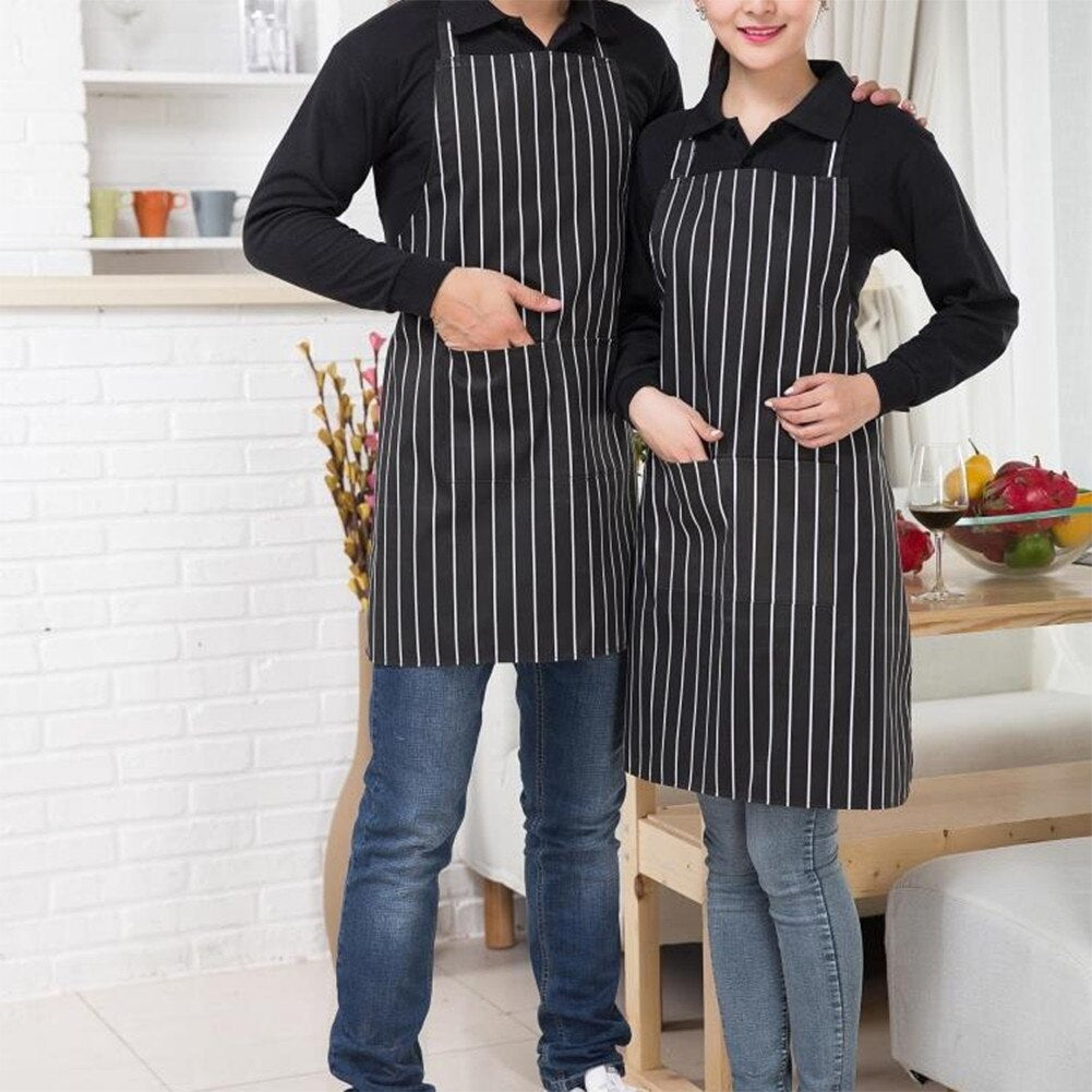 Two cooks wearing striped halter aprons preparing food in a kitchen