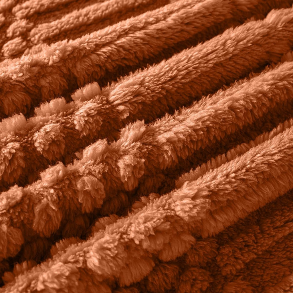 Rust colored fleece throw blanket folded on a sofa, view 4