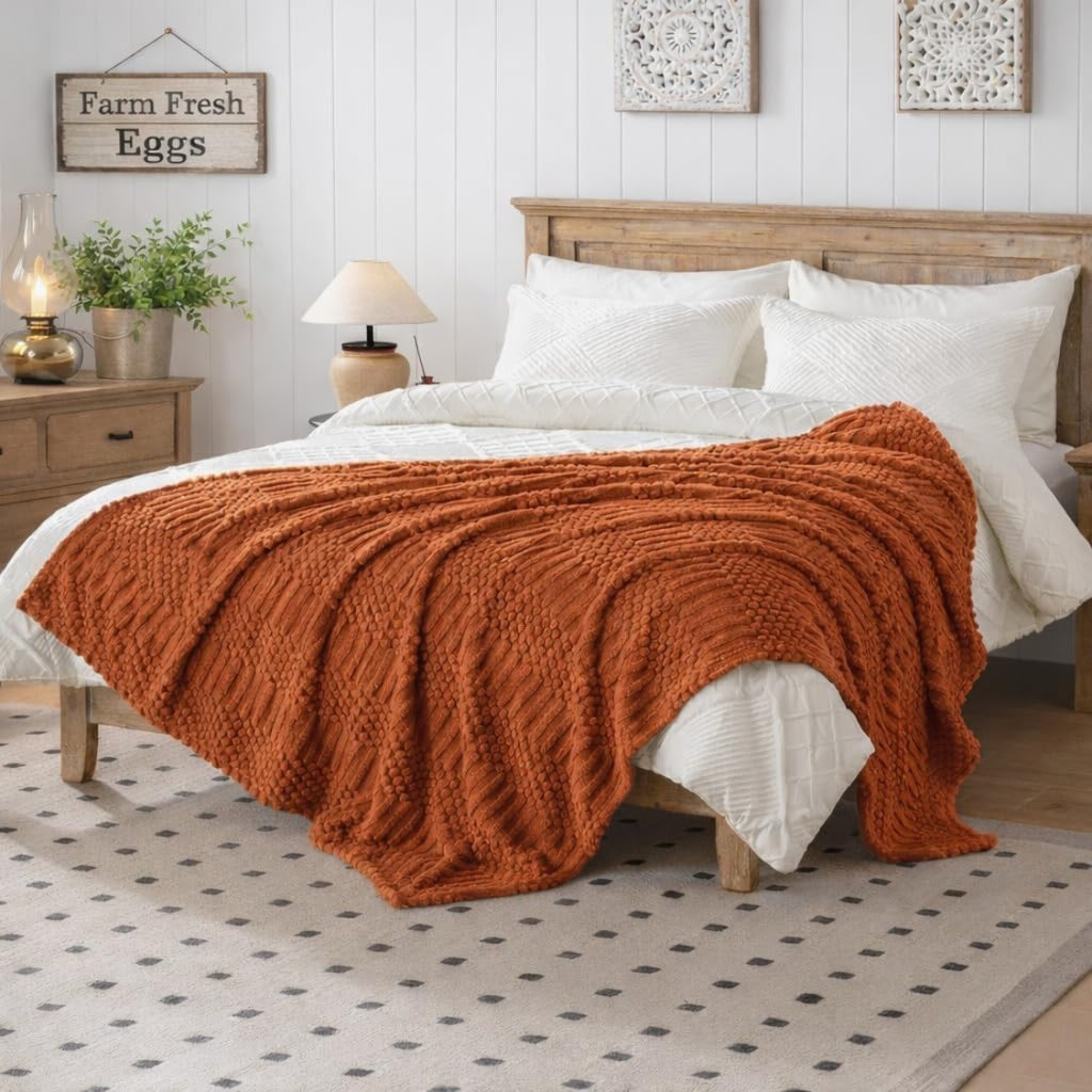 Rust colored fleece throw blanket folded on a sofa, view 3