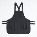 Black kitchen apron shown flat with adjustable waist ties
