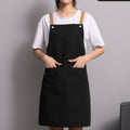 Woman wearing a black canvas kitchen apron with a bib front