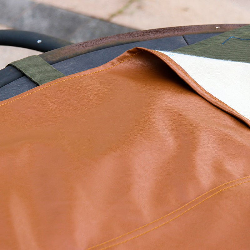 Close-up of the soft tan leather and stitched edge of the apron