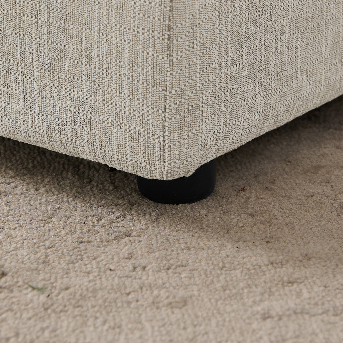 Close-up of the low plastic foot beneath the linen pet sofa